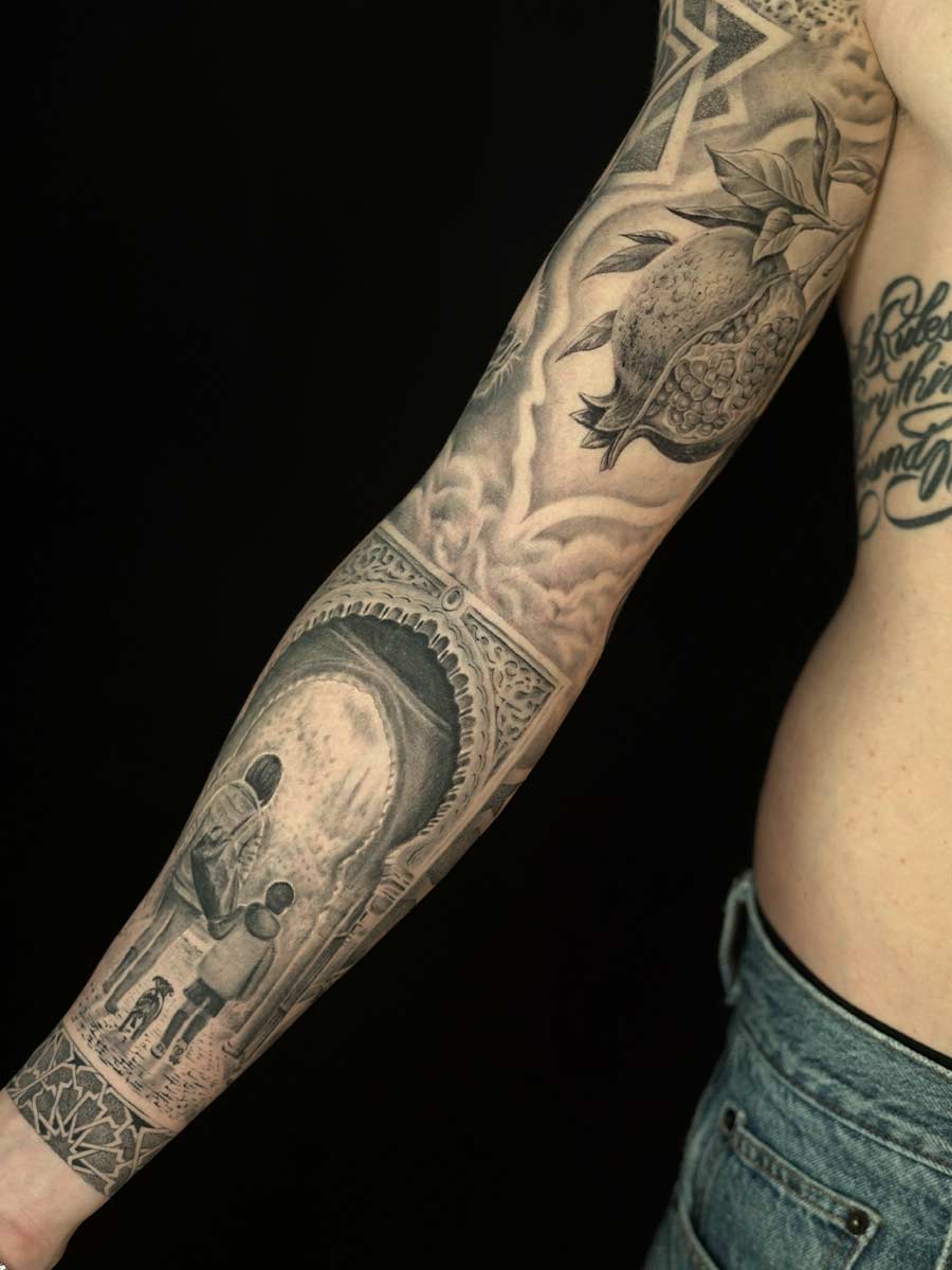 Black-and-grey full sleeve tattoo with pomegranate, archway and family scene